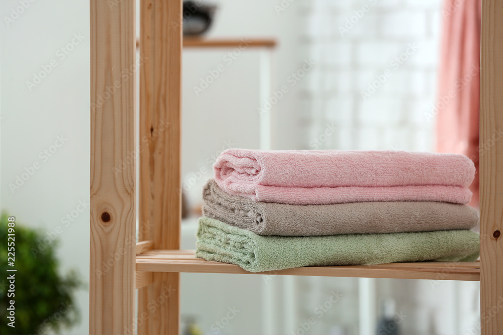 Stack of clean towels on shelf in bathroom
