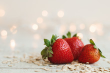 Fresh Strawberry And Raw Oats On Wooden Table, Blurred Lights As Background