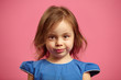 © Ilshat - Close up portrait of charming little girl with serious look on pink isolated.