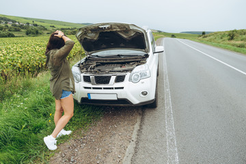 Wall Mural - young adult woman standing near broken car on highway and talkin