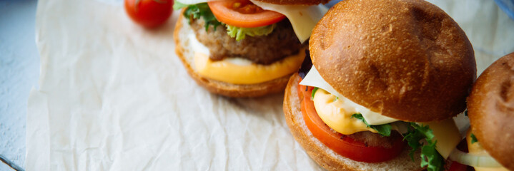 Tasty burger with beef with spinach and blue cheese served on a small board on a wooden background.