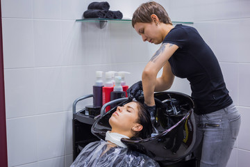 Professional hairdresser, stylist washing hair of woman client at salon, studio. Beauty and fashion concept