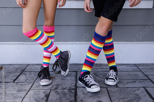 Fotografie, Obraz Tween Girls Legs with Colorful Striped Socks and Tennis Shoes