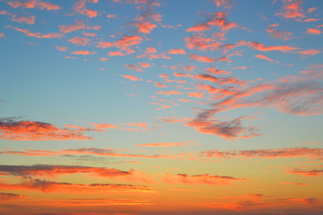 Wall Mural - Pink and orange clouds on a blue sky at dawn just before sunrise background