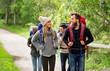 travel, tourism, hiking and people concept - group of happy friends or travelers with backpacks