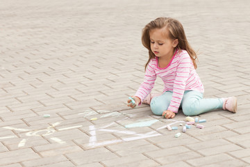 Wall Mural - little girl draws a chalk