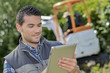 © auremar - Man looking at tablet, digger working in background