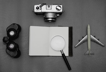 Flat lay of notebook on work desk with retro camera and telescope