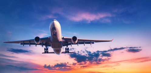 landing airplane against colorful sky at sunset. landscape with aircraft is flying in the blue sky w