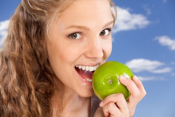 Wall Mural - Beautiful young woman eating apple, close-up