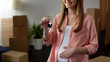 Pregnant woman holding key from new apartment, affordable bank lending, mortgage