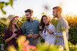Happy friends having fun drinking wine at winery vineyard - Friendship concept with young people enjoying harvest time together