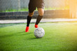 © Koonsiri - Soccer player speed run to shoot ball to goal on artificial turf.
