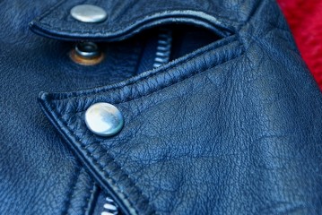 part of a black leather jacket with a gray metal rivet on the collar