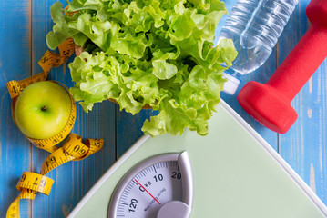 Wall Mural - Diet and Healthy life Concept. Green apple and Weight scale measure tap with fresh vegetable, clean water and sport equipment for women diet slimming