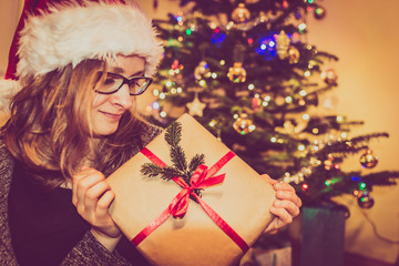 Attractive woman with christmas gift box near tree