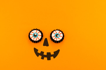 Eyes pumpkin monster from paper orange background