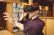 © Wavebreak Media - College student using virtual reality headset in library
