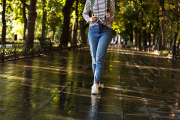 Sticker - Young woman walking outdoors with backpack and camera.