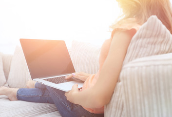 Wall Mural - young woman working with laptop sitting on sofa