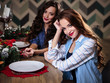 © cherry_d - Pretty twins young women together in a kitchen room, casual home style, new year and christmas decorations