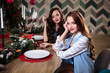 © cherry_d - Pretty twins young women together in a kitchen room, casual home style, new year and christmas decorations