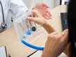 © anusak - I can't use this code.close up hand holding medical equipment. doctor explaining patient use Incentive Spirometer.