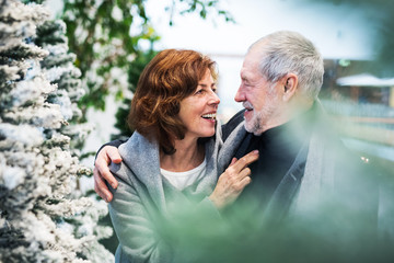 A portrait of senior couple in shopping center at Christmas time.