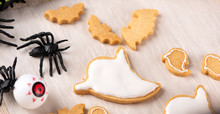 Fresh Homemade Decorating Halloween Cookies With Ghost, Creeping Spider, Bat, Haunted Castle And Horrifying Eyeball On Wooden Background, Copy Space