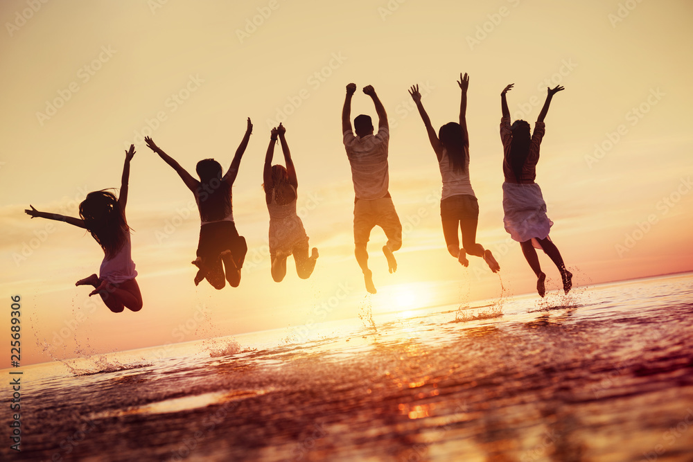 Group of happy friends jumps in sunset water - obrazy, fototapety, plakaty 