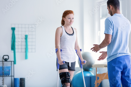 Fotomural Woman with crutches during rehabilitation with helpful physiotherapist