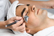 Facial beauty treatment of good looking man with oxygen epidermal peeling at cosmetic beauty salon.