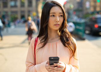 Sticker - Asian woman in city walking using cell phone