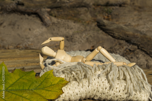 Fotografie, Obraz Dummy for drawing in relaxing pose lays on the warm scarf near fallen leaves