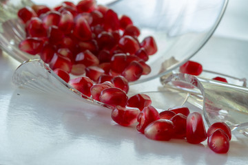 Wall Mural - pomegranate seeds on broken glass plate and on white background