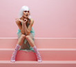 Female model with creative makeup on pink step