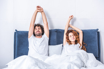 beautiful happy young couple waking up together in bed