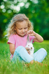 Girl with a cute little rabbit, outdoor, summer day