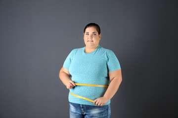 Canvas Print - Overweight woman with measuring tape on gray background