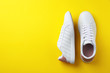 © New Africa - Pair of sneakers on color background, flat lay. Space for text