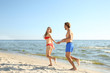 © New Africa - Happy young couple in beachwear running together on seashore