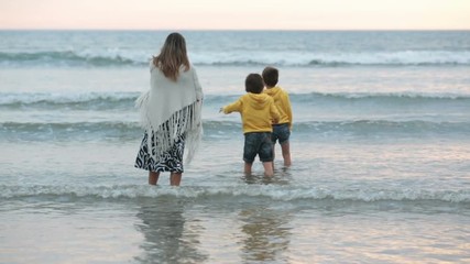 Poster - Young mother with her beautiful children, enjoying the sunset over the ocean on a low tide in Devon, England