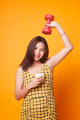 Healthy Asian woman drinking a glass of milk and dumbbell.