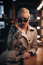 Fashion model in a trench coat and sunglasses