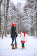 © alexkich - A winter fairy tale, a young mother and her daughter ride a sled