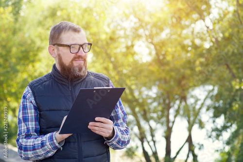 Fotografía Male ecologist with glasses writes information about environmental problems