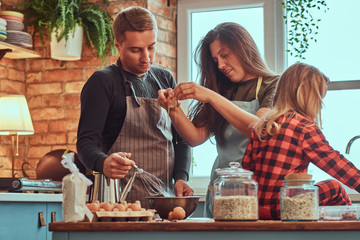 Wall Mural - Mom dad and little daughter together cooking breakfast in loft style kitchen.