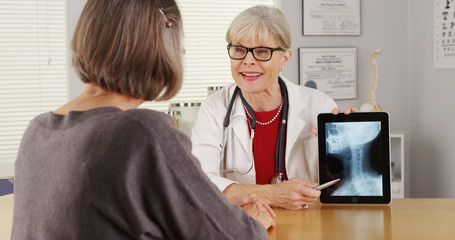 Wall Mural - Senior doctor tablet talking x-ray