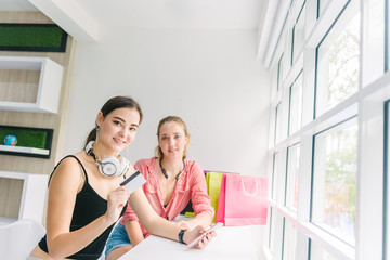 two caucasian woman enjoy shopping online