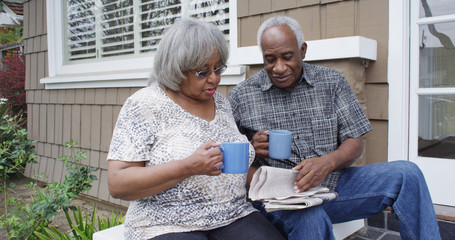 Mature black couple drinking outdoors